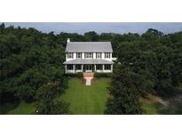 Two story home with metal roof and lush landscaping at 23337 Lake Lindsey Rd, Brooksville, FL 34601