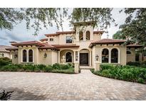 Two-story house with a tile roof and landscaped front yard at 9943 Milano Dr, Trinity, FL 34655