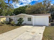 Charming home with a well-maintained front yard and long driveway leading to an attached single car garage at 7206 Ashwood Dr, Port Richey, FL 34668