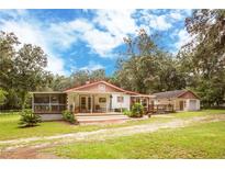 Charming ranch home with a large screened porch, deck, and fenced yard at 24514 Audubon Dr, Brooksville, FL 34601