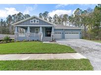 Charming single-Gathering home showcasing a craftsman style exterior, well-manicured lawn, and a spacious three car garage at 3898 Southern Valley Loop, Brooksville, FL 34601