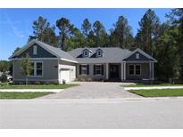 Charming home with a paved driveway, attached garage, manicured lawn and a traditional architectural style at 4676 Hickory Oak Dr, Brooksville, FL 34601