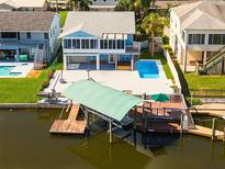 Aerial view of waterfront home with private pool, dock, and boat lift at 7637 Hatteras Dr, Hudson, FL 34667