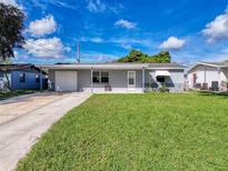 House exterior featuring a gray color scheme and a well-maintained lawn at 3809 Burden St, New Port Richey, FL 34652