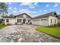 New construction home with three-car garage and paver driveway at 19395 Sheltered Hill Dr, Brooksville, FL 34601