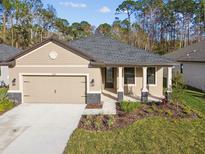 Charming single-story home with a manicured lawn, neutral paint, and stone accents on the porch and garage at 11512 Weaver Hollow Rd, New Port Richey, FL 34654
