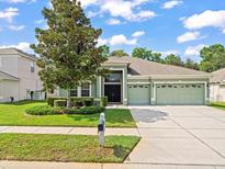 Two-story house with green exterior and three-car garage at 4264 Braemere Dr, Spring Hill, FL 34609