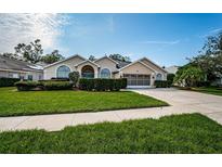 Single-story house with a landscaped yard and a two-car garage at 1810 Kinsmere Dr, Trinity, FL 34655