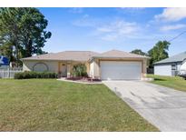 Single-story house with attached garage, and well-manicured lawn at 3195 Montague Ave, Spring Hill, FL 34608