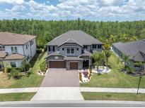Beautiful two-story home featuring a well-manicured front yard, a three-car garage and tile roof at 6120 Marsh Trail Dr, Odessa, FL 33556