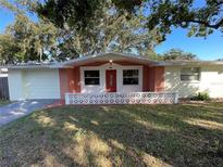 Brick front exterior with red door and well-maintained lawn at 5319 Whippoorwill Dr, Holiday, FL 34690