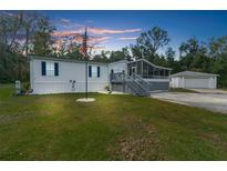 Single-wide mobile home with screened porch and American flag at 13477 Brooksville Rock Rd, Weeki Wachee, FL 34614