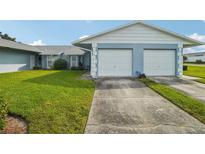Light blue home exterior with a 2-car garage at 8833 Manos Cir # 8833, New Port Richey, FL 34655