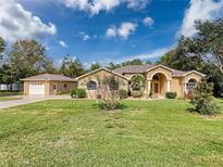 Single-story home with a large yard, attached garage, and neutral color scheme at 11281 Godwit Ave, Weeki Wachee, FL 34613