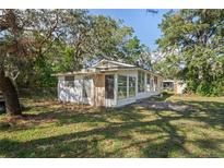 White house with boarded-up front door and large tree at 9305 Kiowa Dr, New Port Richey, FL 34654