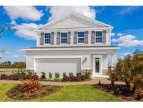 Two-story home with gray siding, gray shutters, and a light blue front door at 10421 High Noon Trl, Parrish, FL 34219