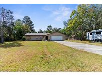 Single-story house with attached garage and large yard at 13242 Little Farms Dr, Spring Hill, FL 34609