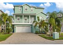 Beautiful light green two story house with a white garage door and a brick driveway at 5632 Egrets Pl, New Port Richey, FL 34652