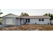 Newly renovated light gray house with white garage door at 6417 Sutherland Ave, New Port Richey, FL 34653