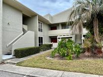 Two-story building with a walkway, landscaping, and stairs at 427 Windrush Bay Dr # 427, Tarpon Springs, FL 34689