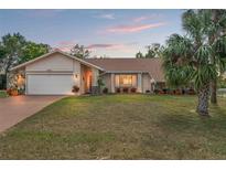 Inviting single-story home with a two-car garage and landscaped yard at 6450 Trade Ct, Spring Hill, FL 34606