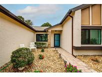 Inviting front entrance with landscaped walkway and seating area at 7499 Heather Walk, Weeki Wachee, FL 34613