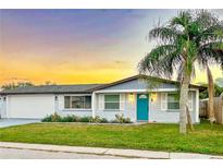 Charming ranch house with teal door and sunset at 3452 Umber Rd, Holiday, FL 34691