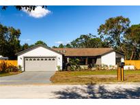 Updated single-story home with a large driveway and landscaped lawn at 9053 Nakoma Way, Weeki Wachee, FL 34613