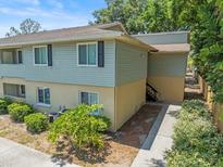 Corner lot of a multi-level home featuring a combination of siding and stucco with lush landscaping and a sidewalk leading to the entrance at 230 Thorn Tree Pl # 230, Brandon, FL 33510