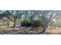 Mobile home with mature trees and a landscaped yard at 6434 Garvey Dr, New Port Richey, FL 34652
