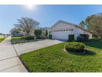 House exterior featuring a two-car garage and well-manicured lawn at 11544 Mcleod St, Spring Hill, FL 34609