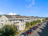 Aerial view of a two-story condominium building with ample parking at 2210 Utopian E Dr # 212, Clearwater, FL 33763