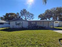 Ranch-style home with covered porch and well-maintained lawn at 7552 Cumber Dr, New Port Richey, FL 34653