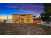 Two-story house with orange accents and a white fence, American flag, and driveway at 10191 Jordan St, Spring Hill, FL 34608