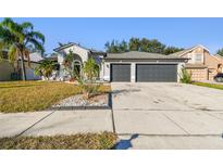 Two-story house with a three-car garage and landscaped front yard at 11528 Andy Dr, Riverview, FL 33569