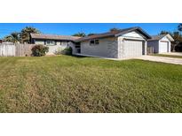 Ranch style home with a well-manicured lawn and attached garage at 9139 Fairweather Dr, Largo, FL 33773