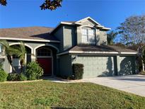 Two-story house featuring a red door and attached two-car garage at 1922 Oswego Dr, Holiday, FL 34691