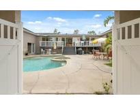 Inviting pool area with a spa, patio furniture, and well-maintained landscaping, framed by an open gate at 7941 Sycamore Dr, New Port Richey, FL 34654
