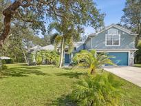 Two-story house with blue siding, stone accents, and a landscaped lawn at 92 Randolph Ave, Spring Hill, FL 34606