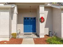 Inviting entryway with a bright blue double door and festive wreath at 7423 Woodhollow Rd, Spring Hill, FL 34606