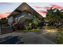 Two-story condo building with lush landscaping and walkway at 7717 Cosme Dr # 2, Hudson, FL 34667