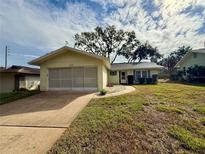 Ranch-style home with a single-car garage and well-maintained lawn at 8704 Winding Wood Dr, Port Richey, FL 34668