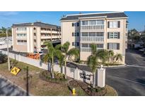 Exterior view of Port Bellaire condo community featuring lush landscaping and building entry at 155 Bluff View Dr # 103, Belleair Bluffs, FL 33770