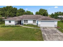 Charming single-story home with white siding, attached garage, and a landscaped front yard at 2118 Huntington Ave, Sarasota, FL 34232