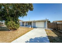 Charming single-story home featuring a well-maintained lawn, driveway, and a welcoming front porch at 3444 Clydesdale Dr, Holiday, FL 34691