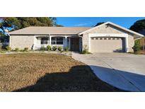 Brick ranch house with attached garage and well-maintained lawn at 6288 Airmont Dr, Spring Hill, FL 34606
