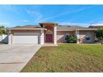 Single-story home with attached garage, driveway, and front yard at 714 Charlotte Ave, Tarpon Springs, FL 34689