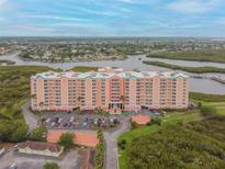 Aerial view of a waterfront condo building with parking and a pool at 4516 Seagull Dr # 413, New Port Richey, FL 34652