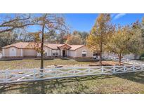 Single-story house with white fence and a large yard at 5085 Bone Ln, Brooksville, FL 34604