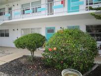 Exterior view of a condo building with teal accents and lush landscaping at 5945 21St N St # 2, St Petersburg, FL 33714